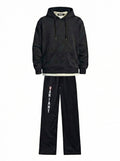Black tracksuit with 'Variant' branding on pants against a white background